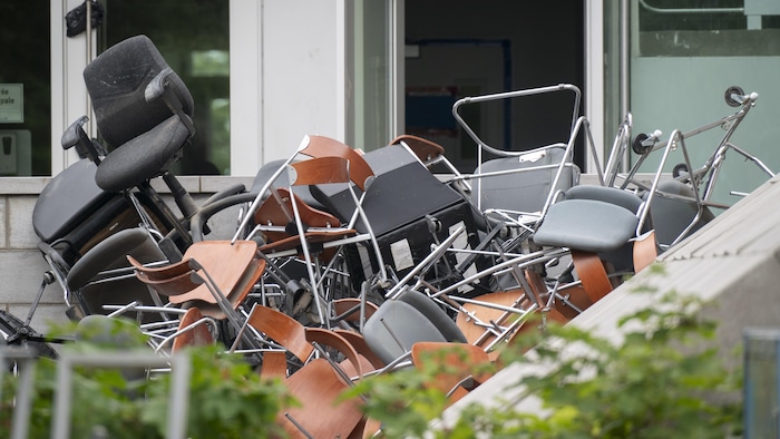 Des chaises empilées à l'extérieur.