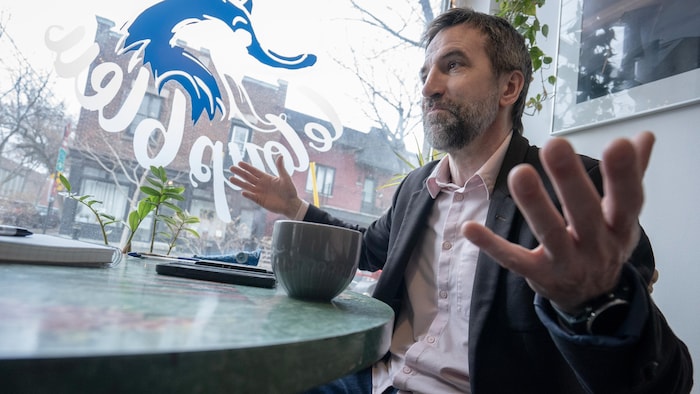 Attablé dans un café, Steven Guilbeault gesticule.