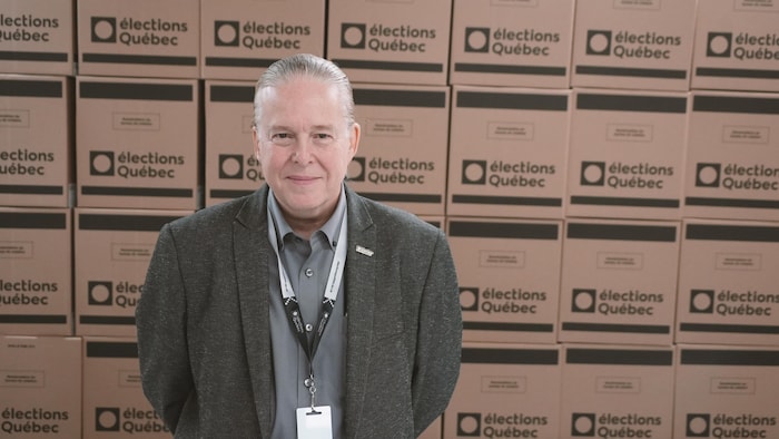 Eric Saint-Pierre devant des boites de scrutin pour l'élection provinciale.
