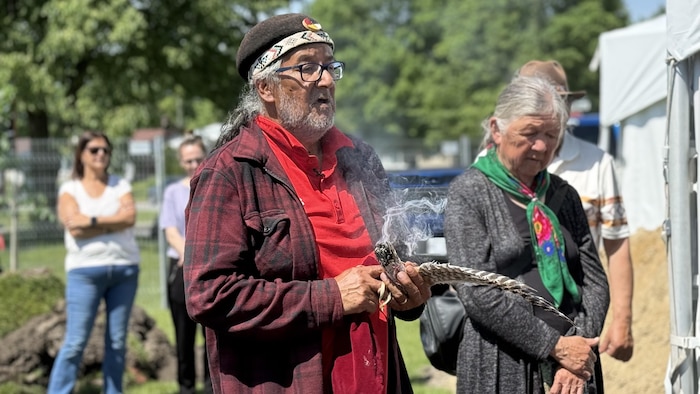Un homme avec une plume et de la sauge et une femme à côté.