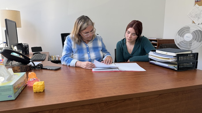 Geneviève et Anouk regardent un dossier.