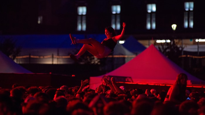 Une femme dans les airs au-dessus d'une foule.
