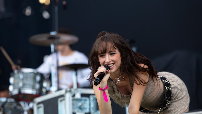 La chanteuse est penchée vers l'avant avec son micro.