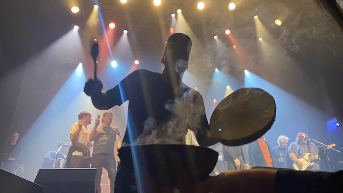 Un homme avec un tambour et de la fumée devant lui.