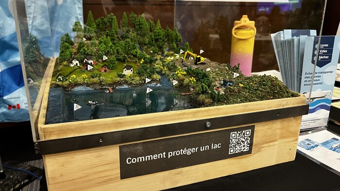 Une maquette d'un lac avec des habitations et une foret.