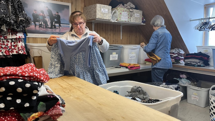 Deux bénévoles trient des vêtements donnés à la friperie.