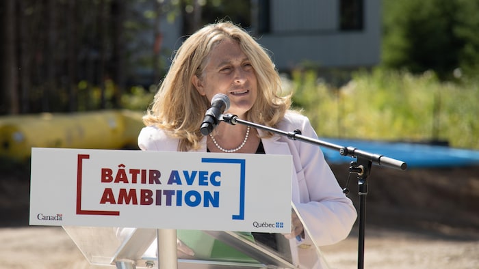 La ministre parle à un lutrin.