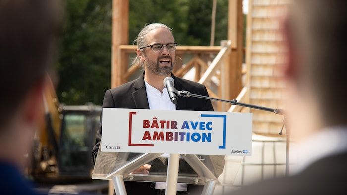 Un homme parle à un lutrin.