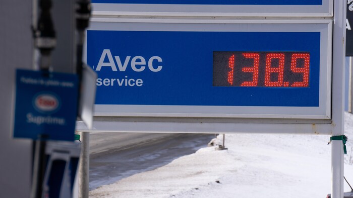 Un panneau avec un écran indiquant le prix de l'essence à la pompe.