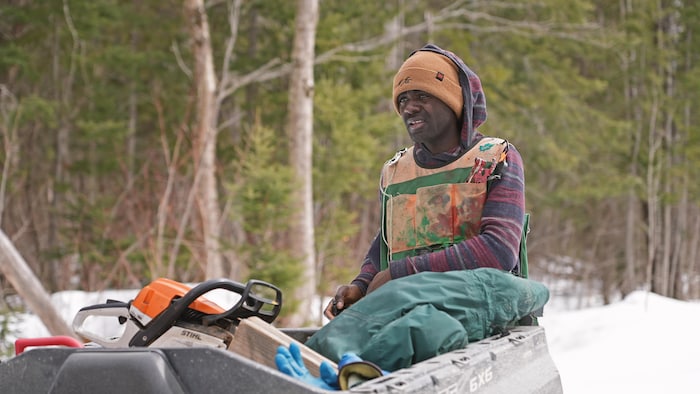 Hardy Luyeye derrière son vtt dans une érablière. 