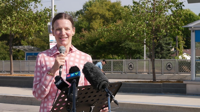 Une femme parle devant des microphones.