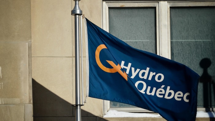 Un drapeau portant le logo d'Hydro-Québec devant la fenêtre d'un édifice.