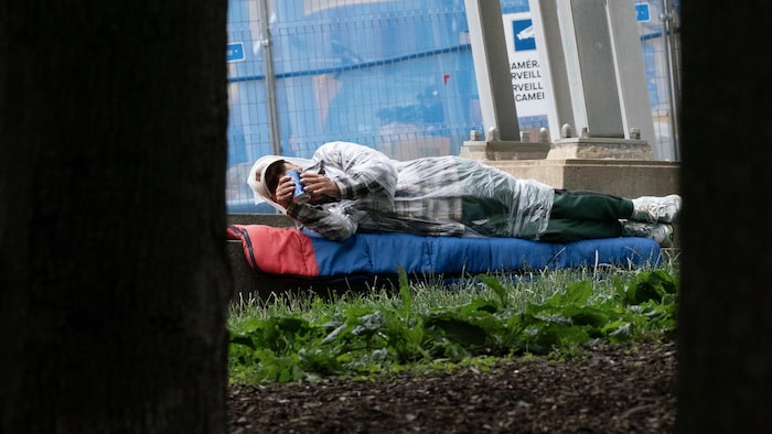 Un itinérant est couché au sol, à Montréal.