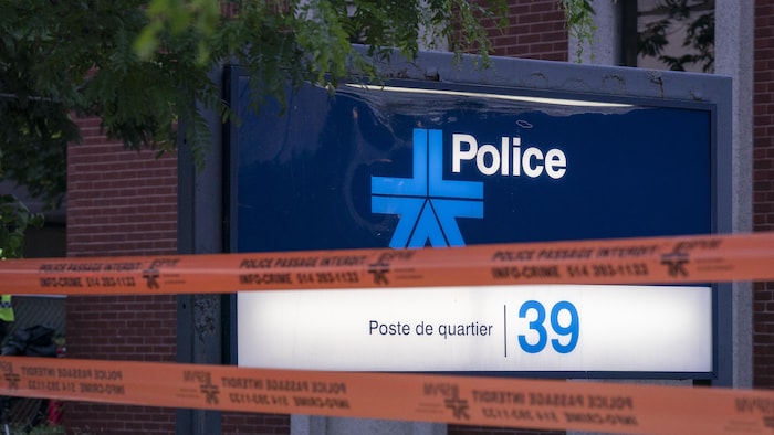 Des rubans orange ont été installés devant un panneau du Service de police de la Ville de Montréal.