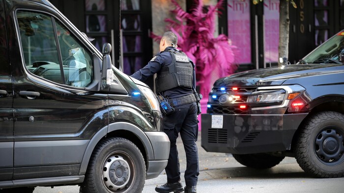 Un policier mène une intervention devant un commerce de la rue Granville à Vancouver.