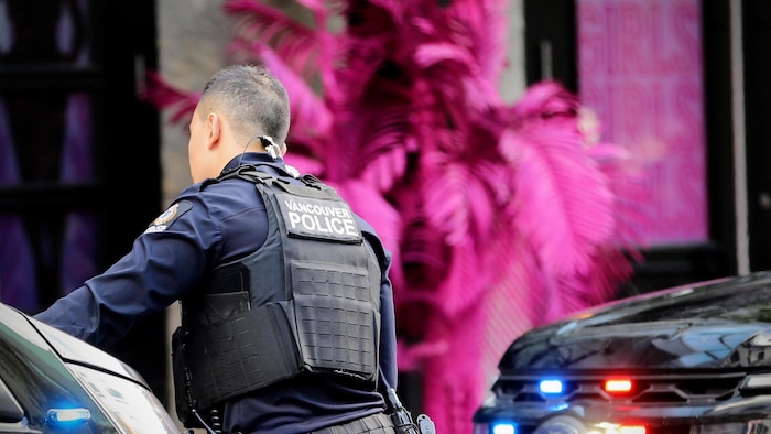 Un policier de Vancouver devant une voiture de police