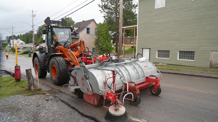 De la machinerie nettoie la rue des débris.