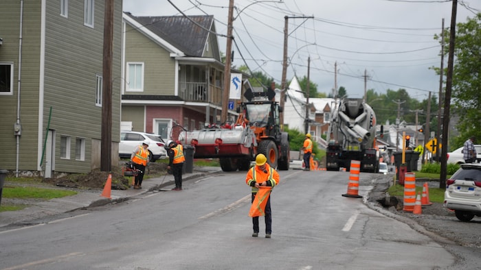 Des ouvriers et des machineries s'affairent à réparer la route.