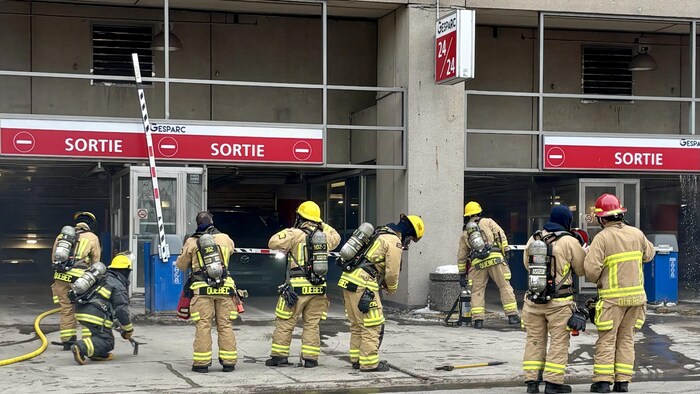 Des pompiers devant un stationnement à étages.