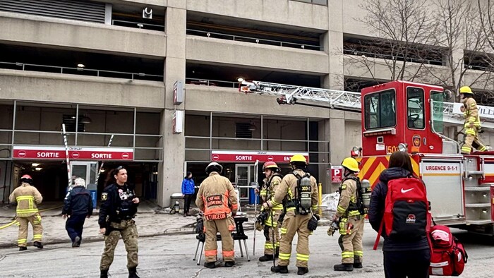 Des pompiers devant un stationnement à étages.
