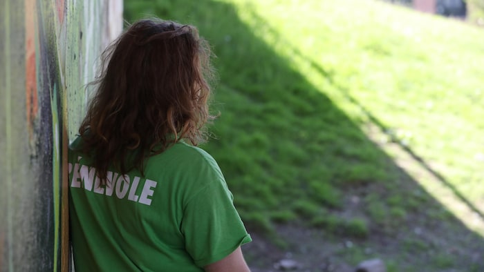 Une femme de dos regarde au loin.