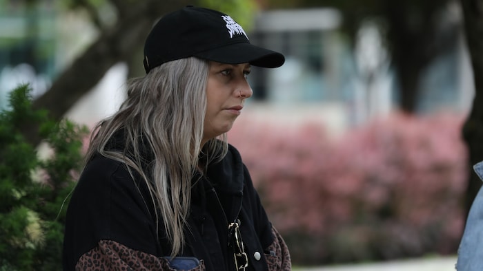 Une femme portant une casquette écoute attentivement une autre personne
