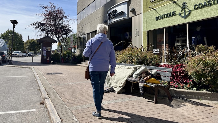 Un itinérant couché sur un banc au centre-ville de Rimouski, le 15 septembre 2026.
