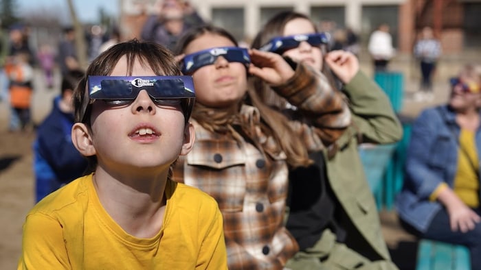 Des enfants munis de lunettes de protection observent l'éclipse solaire du 8 avril 2024.
