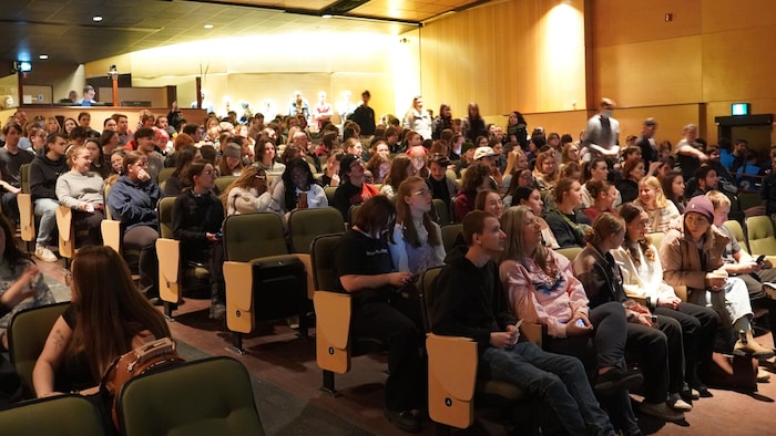 Le public d'un amphithéâtre de l'UQAR est presque complet. Des étudiants et des parents y sont assis.