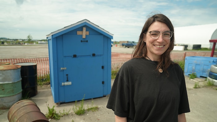 Portrait de Karolyne Beauchamp, devant la grande boîte en bois bleue.