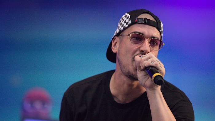 Le rappeur Koriass au micro pendant un spectacle.