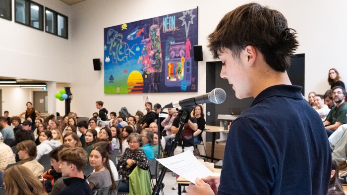 Un étudiant pose sa question au micro.