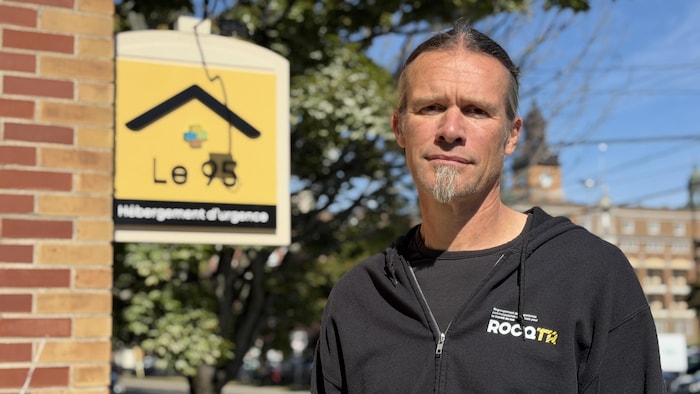 Portrait d'un homme devant une affiche