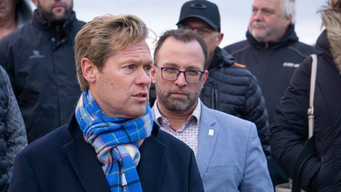 L'homme prend la parole sous le regard attentif du maire de Gaspé positionné juste derrière lui.