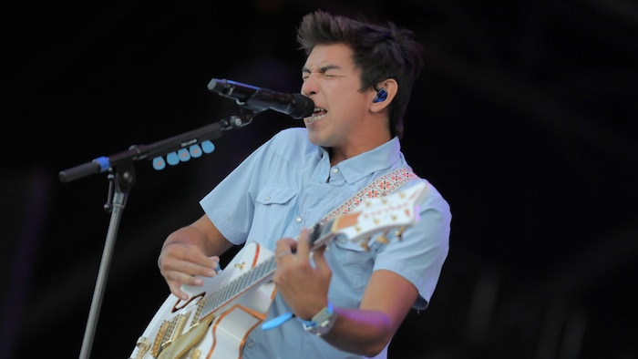 Un chanteur et guitariste sur scène.
