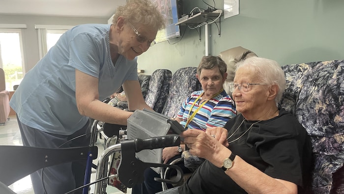 Des personnes âgées regardent une tablette.