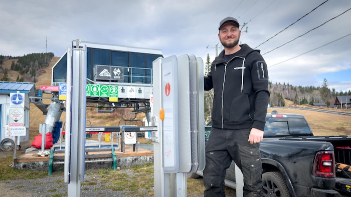 L'installateur pose devant son système de porte automatique.