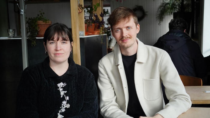 Une jeune femme et un jeune homme dans un café, de face.