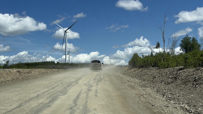 Une route sur un chantier éolien avec un camion à l'avant.