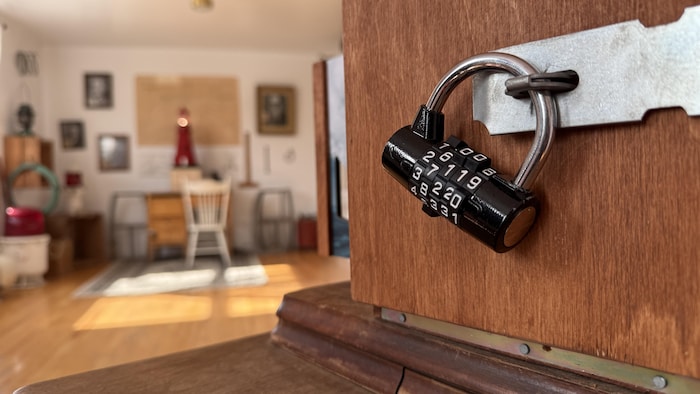 Un cadenas sur une boîte de bois, avec, en arrière-plan, un décor de bureau.