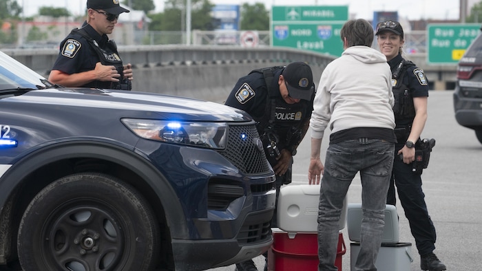 Quelqu'un montre deux glacières à des policiers.