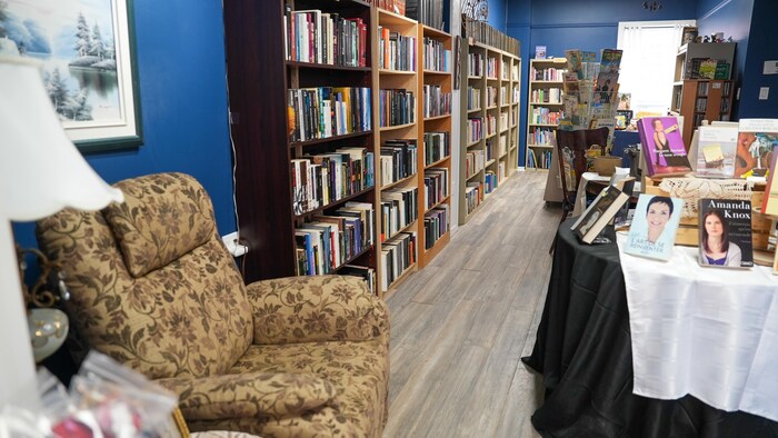 Un fauteuil près d'une étagère pleine de livres.