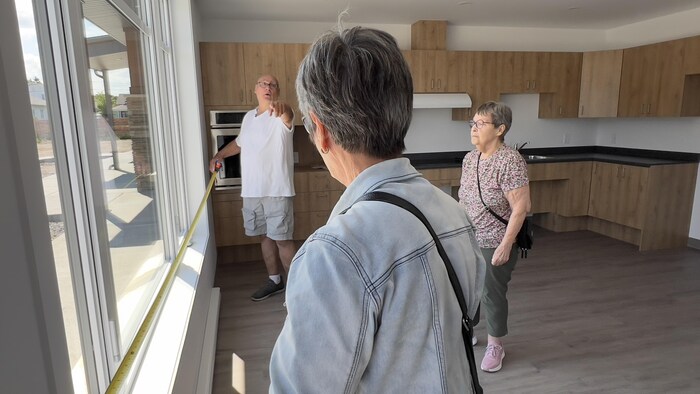 Marie-Paule Ross mesure son futur appartement en compagnie de membres de sa famille.