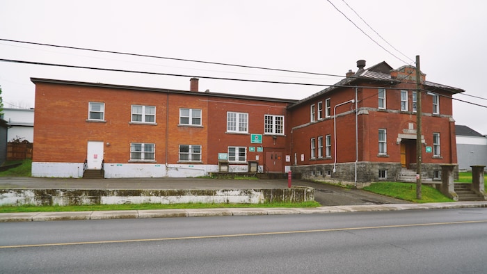 Le manège militaire de Rimouski vu de l'extérieur. Il s'agit d'un édifice en brique brunes. 