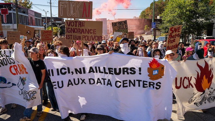 Plusieurs manifestants avec des pancartes en opposition aux centres de données.