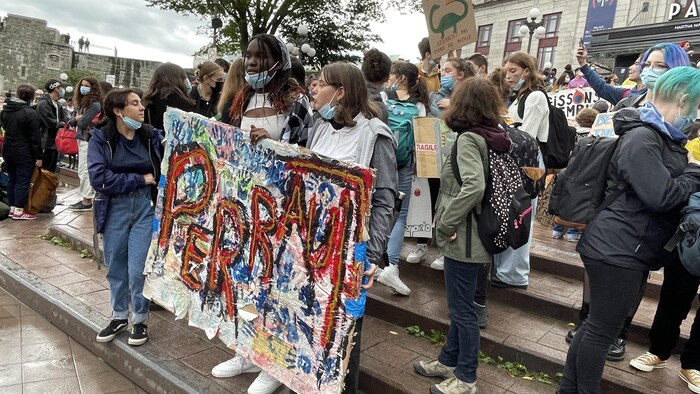 Des élèves de l’école secondaire Joseph-François-Perrault avec leur pancarte.