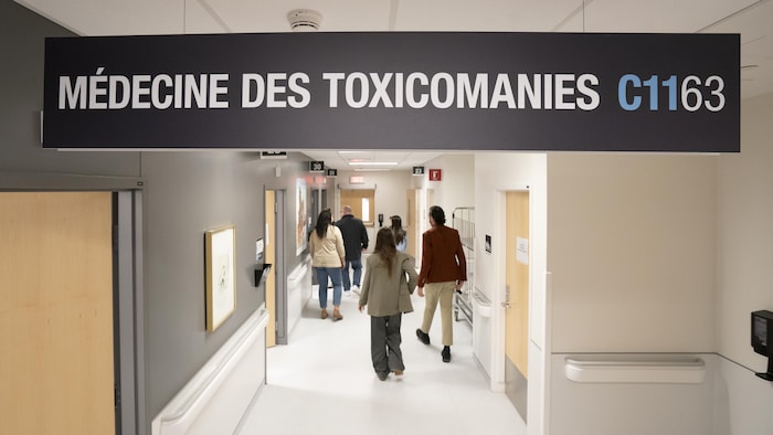 Des gens circulent dans un corridor d'hôpital.
