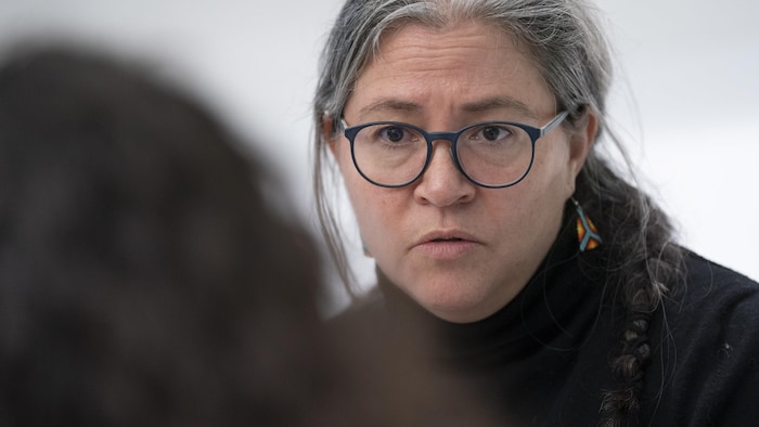 Lucie-Catherine Ouimet discute avec une autre personne de dos.