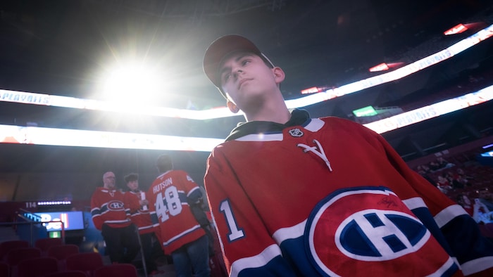 Une garçon debout dans les gradins du Centre Bell. 