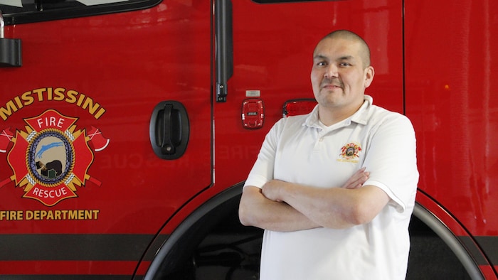 Ryan Gunner devant un camion de pompier.